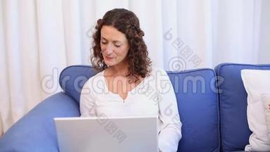快乐的<strong>女人</strong>在沙发上用笔记本电脑，<strong>接电话</strong>